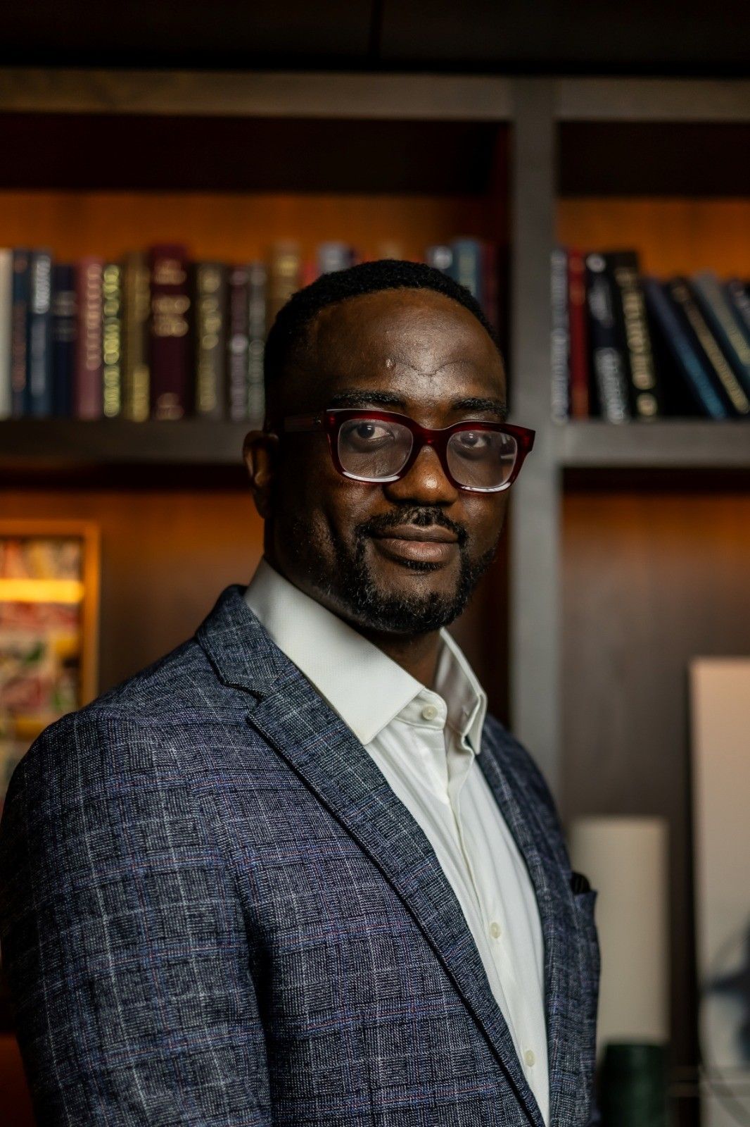 Idahosa Iyawe in front of a bookshelf